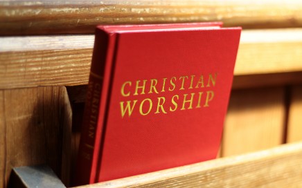 a hymnbook resting in a pew