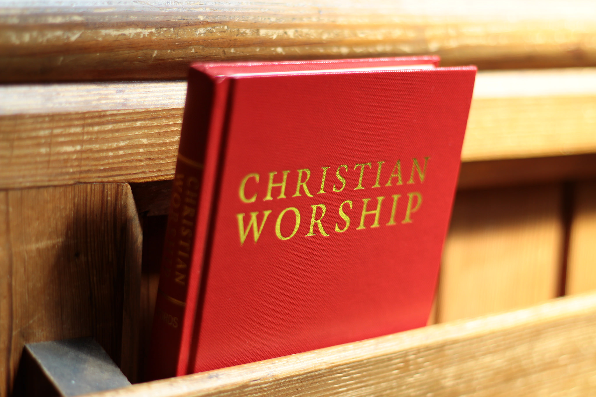 a hymnbook resting in a pew